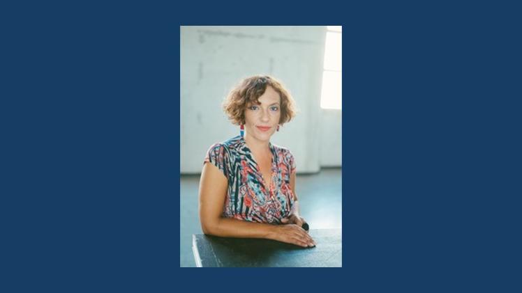 person sitting at table looking directly at camera.